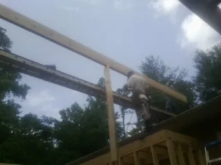 Carpenter setting a ridge beam over a new addition frame — Ice Dam Removal by Roofing Brothers in Mattawa