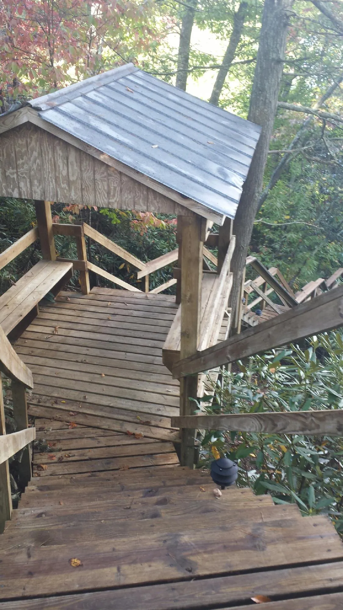 Metal roofed shelter over wooden steps on a wooded walkway — Skylight Repair & Installation work by our crew in Mattawa