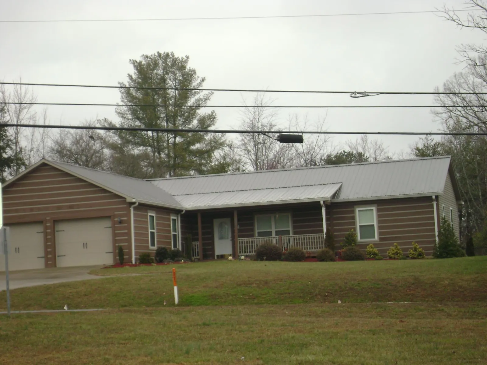 Gray metal roof on a log sided ranch home with a front porch in Mattawa